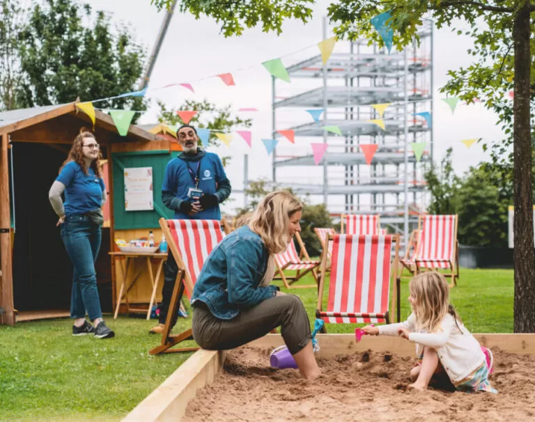 Woman and child playing in sandpit