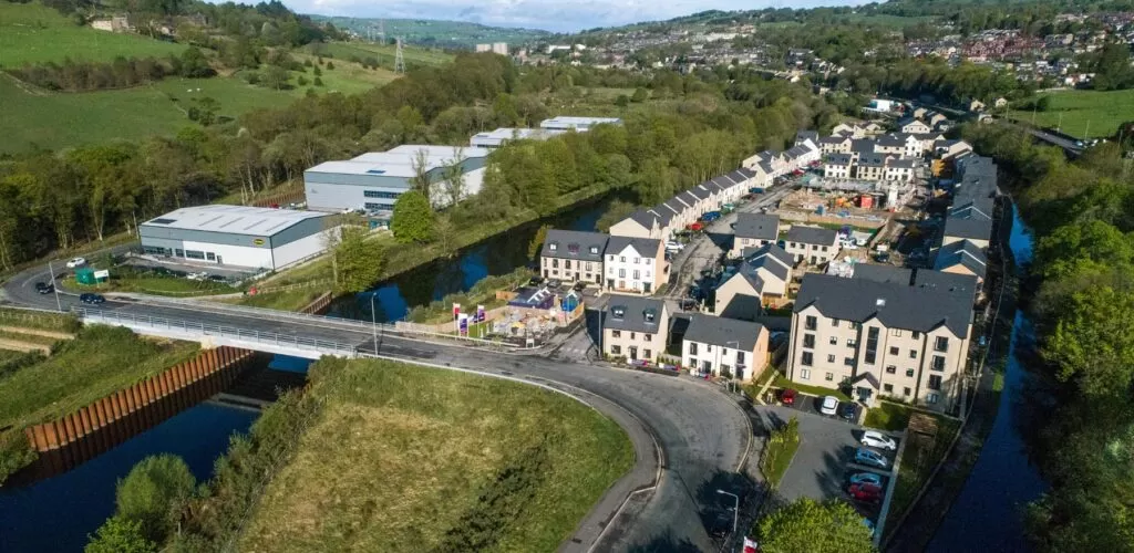 Aerial view of houses and road bridge over river