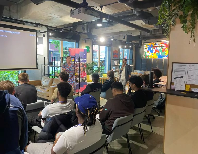 woman presenting to a group of college students in an industrial-style office